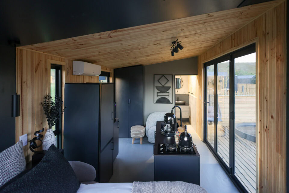 22: black kitchenette, bed and sliding doors onto the deck, pine ceiling, Old Mac Daddy, Elgin Valley