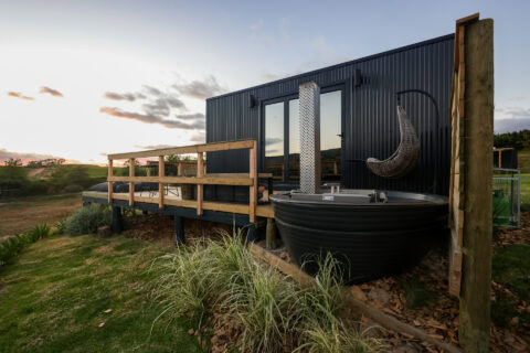 22: black unit with a wood-fired hot tub and a hanging egg chair on the deck, Old Mac Daddy, Elgin Valley