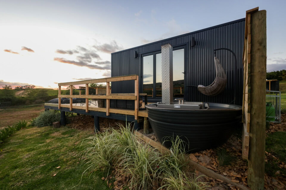 22: black unit with a wood-fired hot tub and a hanging egg chair on the deck, Old Mac Daddy, Elgin Valley