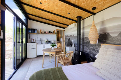 Aardvark: bed and kitchenette under a mountain mural and woven pendant light, Old Mac Daddy, Elgin Valley
