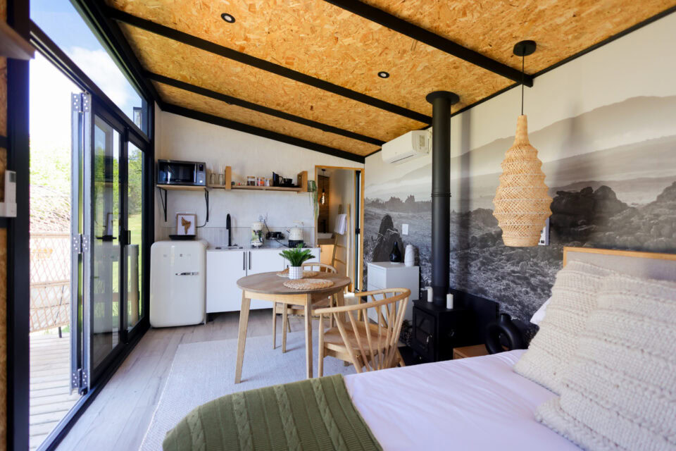 Aardvark: bed and kitchenette under a mountain mural and woven pendant light, Old Mac Daddy, Elgin Valley