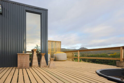 Aardvark: deck with a hot tub and stools, mountains beyond, Old Mac Daddy, Elgin Valley