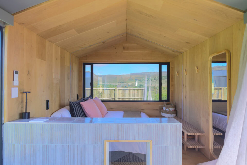 Asem: timber-clad bedroom facing a wide window onto the hills, Old Mac Daddy, Elgin Valley
