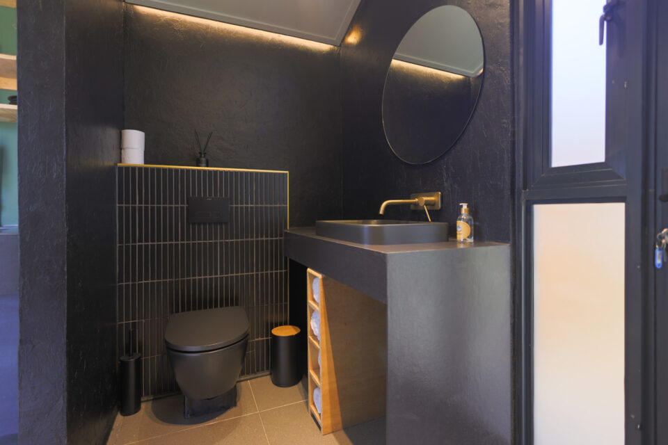 Intak: black bathroom with a round mirror and brass tap, Old Mac Daddy, Elgin Valley