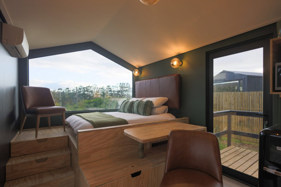 Intak: raised bed under a gabled window, leather chair and glass door onto the deck, Old Mac Daddy, Elgin Valley