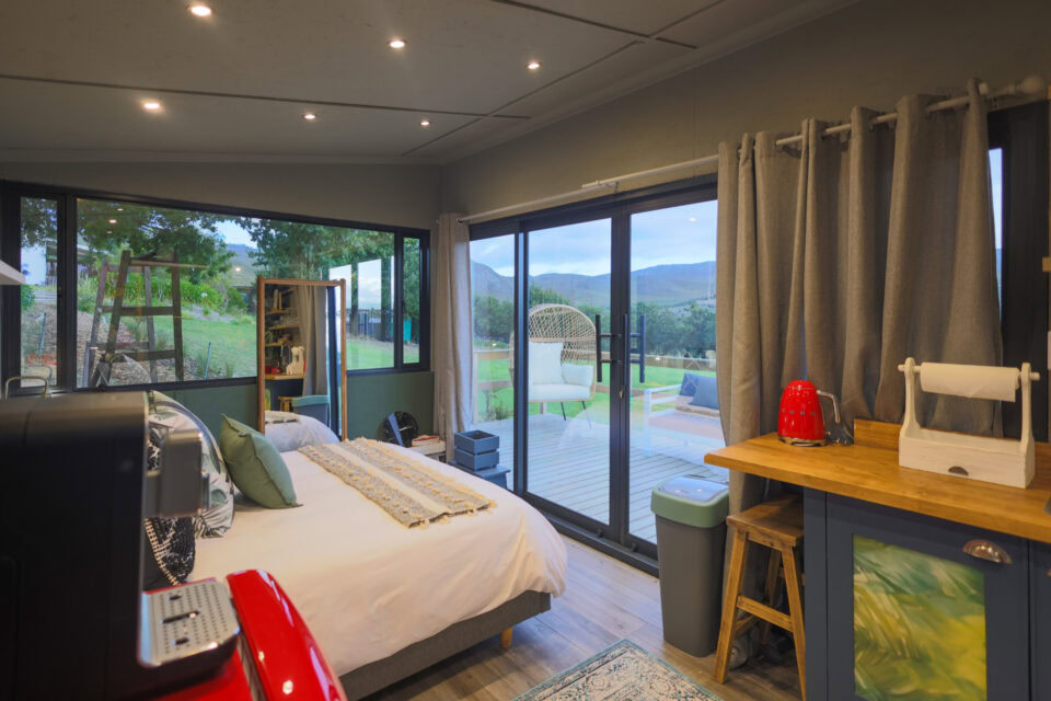 Kaapse Nooi: bed and kitchenette beside sliding doors onto the deck, Old Mac Daddy, Elgin Valley