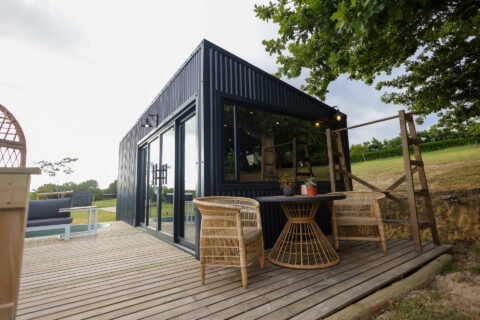 Kaapse Nooi: deck with rattan chairs and a table beside the black unit, Old Mac Daddy, Elgin Valley
