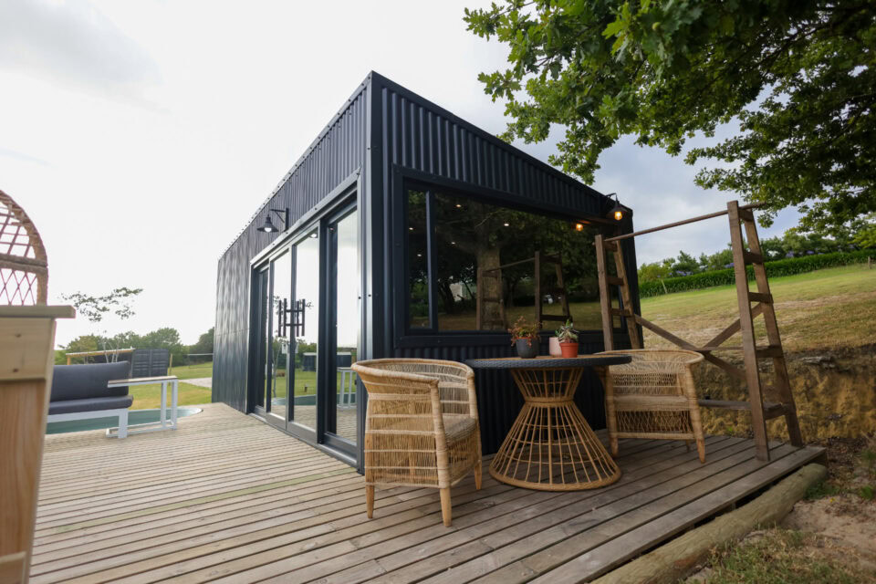Kaapse Nooi: deck with rattan chairs and a table beside the black unit, Old Mac Daddy, Elgin Valley