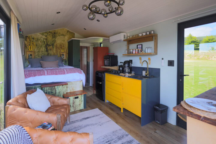Palimpses: bed, leather armchairs and a yellow kitchenette in one open room, Old Mac Daddy, Elgin Valley