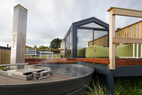 Palimpses: wood-fired hot tub with a perforated chimney beside the black gabled unit, Old Mac Daddy, Elgin Valley