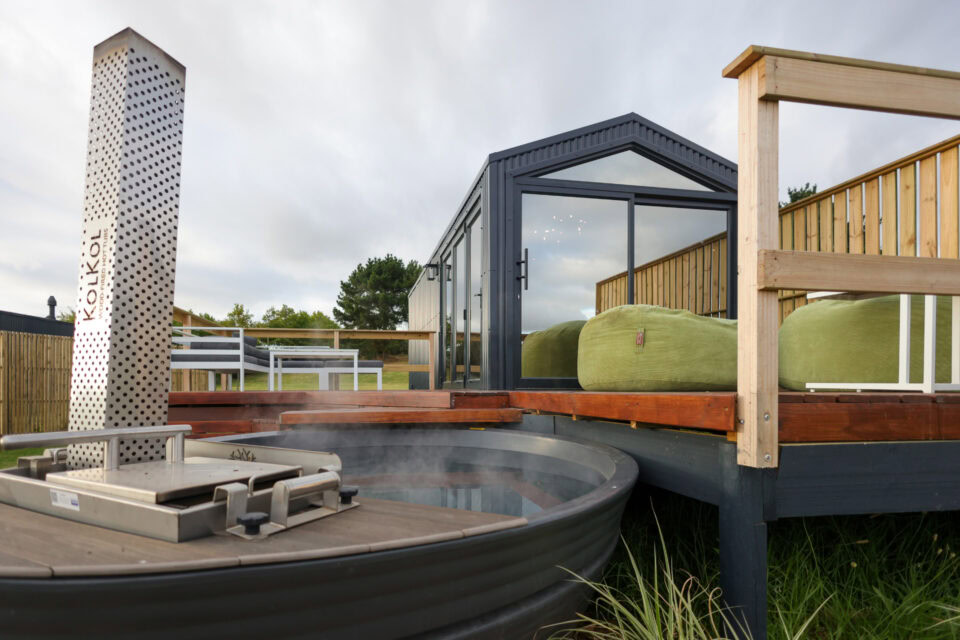 Palimpses: wood-fired hot tub with a perforated chimney beside the black gabled unit, Old Mac Daddy, Elgin Valley