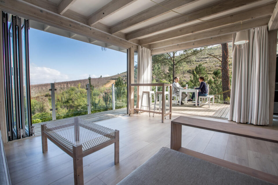 The Dream: living room open to the deck, two guests at a table above the valley, Old Mac Daddy, Elgin Valley