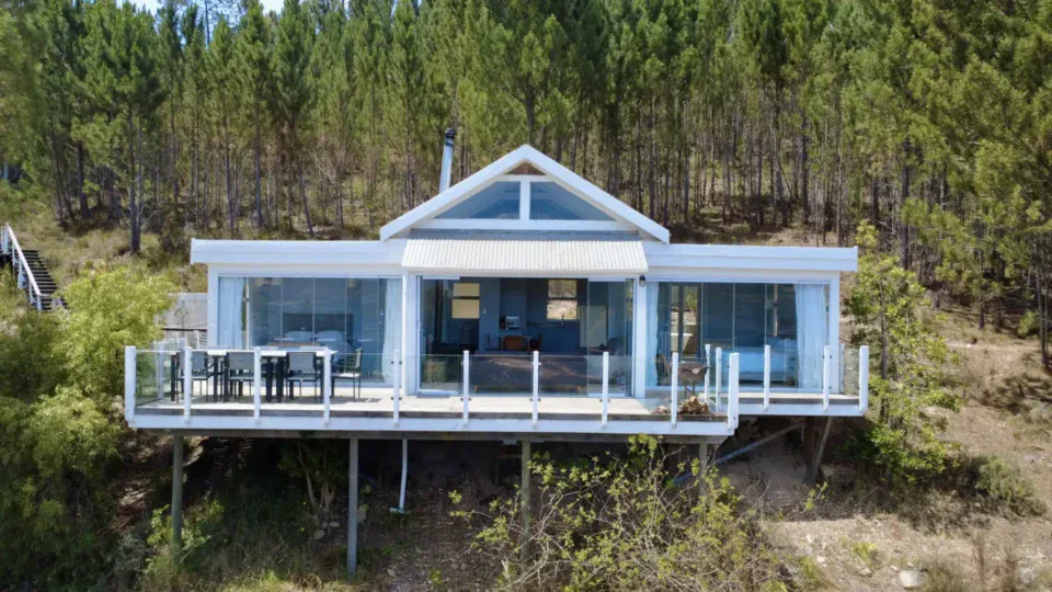 White villa on stilts among pines, with a glass-fronted deck, Old Mac Daddy, Elgin Valley