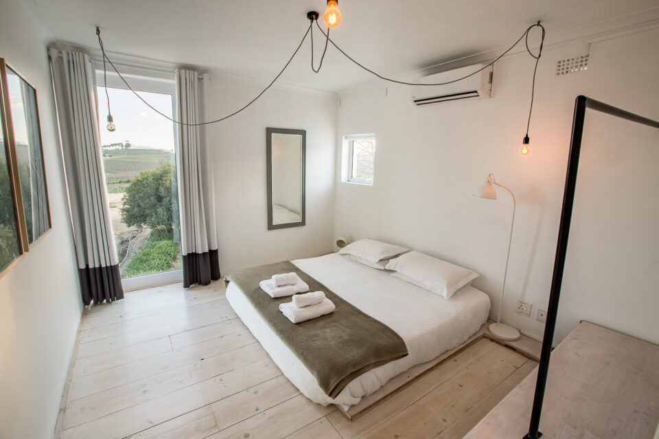 The School House: double bedroom with a tall window onto the farmland, Old Mac Daddy, Elgin Valley