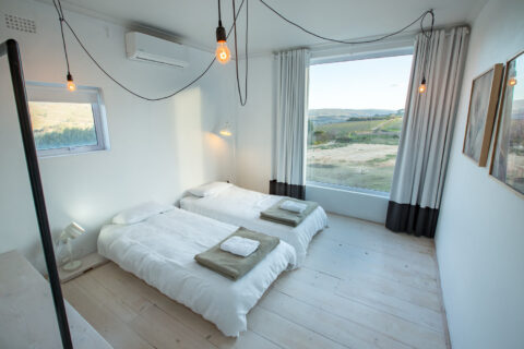 The School House: twin beds below a wide window onto the hills, Old Mac Daddy, Elgin Valley