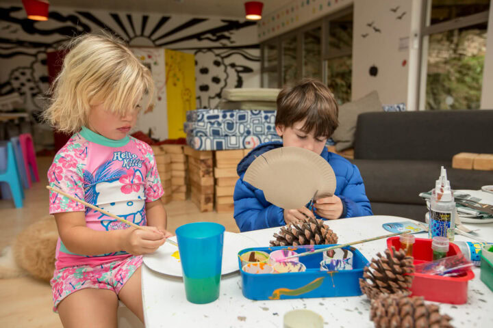 Two children painting pine cones at a craft table, Old Mac Daddy, Elgin Valley