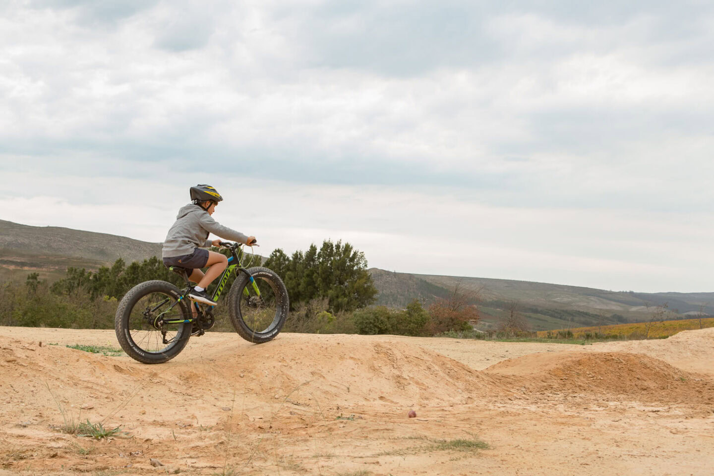 A boy jumping a fat-tyre bike on a dirt pump track, Old Mac Daddy, Elgin Valley