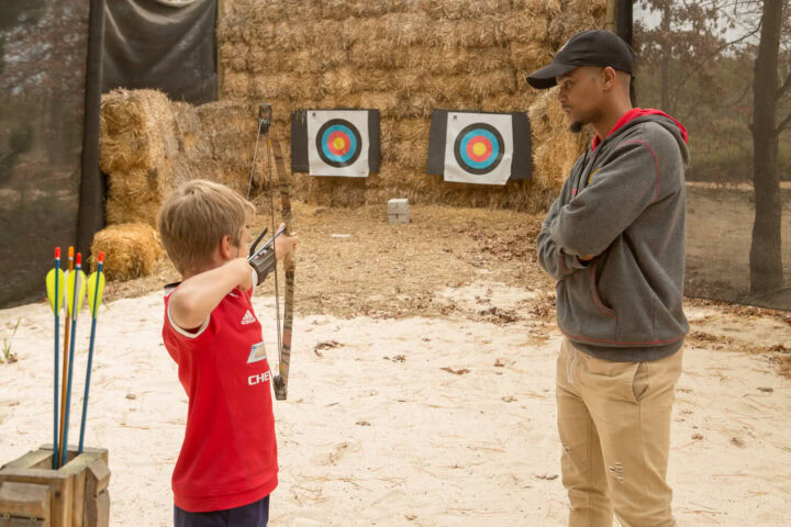 An instructor watching a boy draw a bow at the archery range, Old Mac Daddy, Elgin Valley