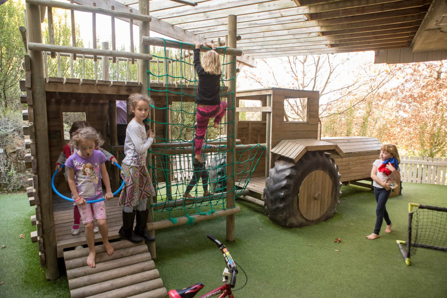 Children climbing on a wooden jungle gym with a tractor play structure, Old Mac Daddy, Elgin Valley