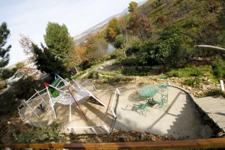 Looking down onto a paved terrace with white railings and green garden chairs, Old Mac Daddy, Elgin Valley