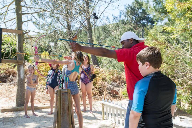 An instructor helping a group of children with archery on the sand, Old Mac Daddy, Elgin Valley