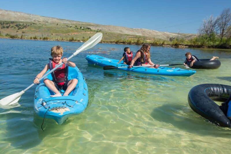 Children in kayaks and on an inner tube on the lake, Old Mac Daddy, Elgin Valley