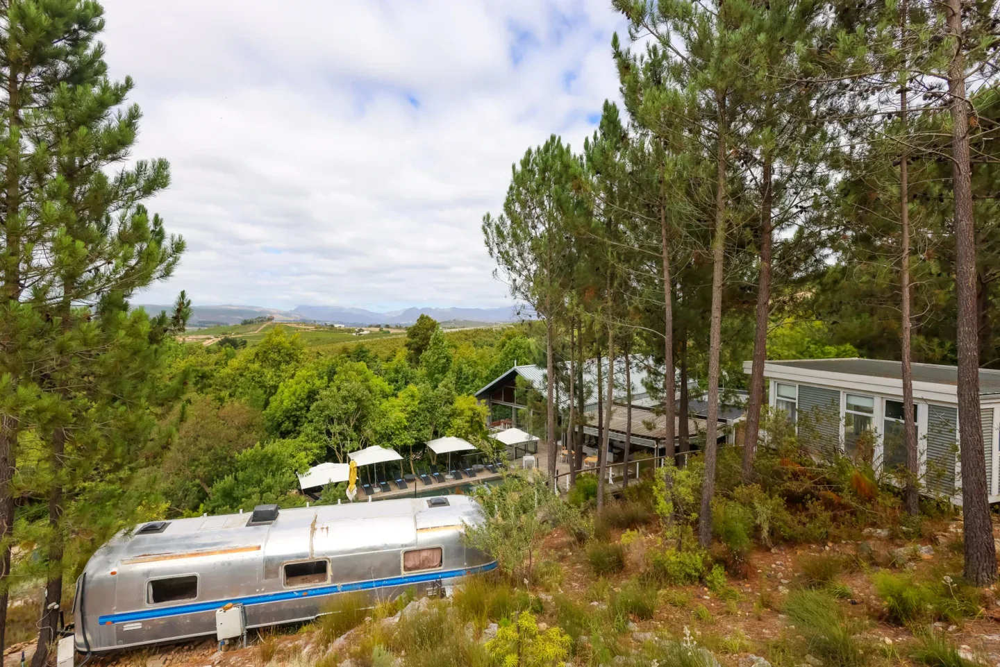 An Airstream on the hillside with the estate and valley behind, Old Mac Daddy, Elgin Valley
