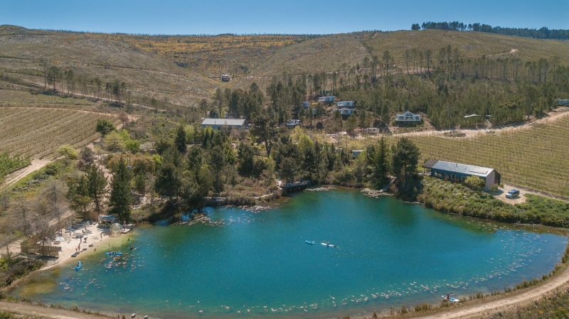 Aerial view of the lake with the estate's buildings and orchards on the hillside behind, Old Mac Daddy, Elgin Valley