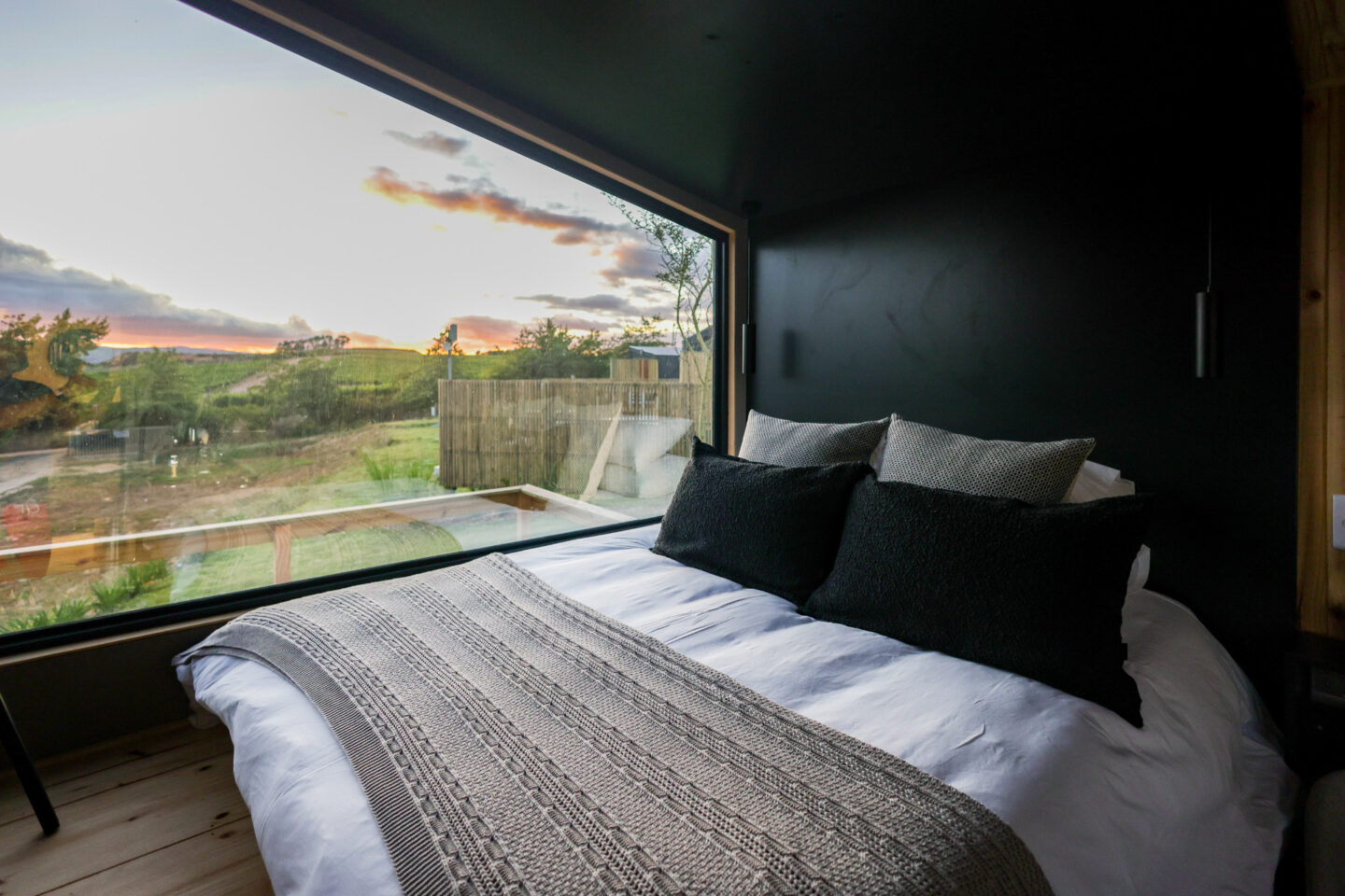 Klein Paradys: bed beside a wide picture window looking out at sunset, Old Mac Daddy, Elgin Valley
