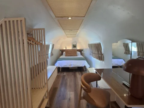 Sovereign 59: looking down the Airstream to the bed, past a desk, a leather chair and a cane ceiling panel, Old Mac Daddy, Elgin Valley