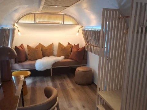 Sovereign 59: the living area, with a cushioned banquette, a leather pouf and a slatted plywood wardrobe, Old Mac Daddy, Elgin Valley