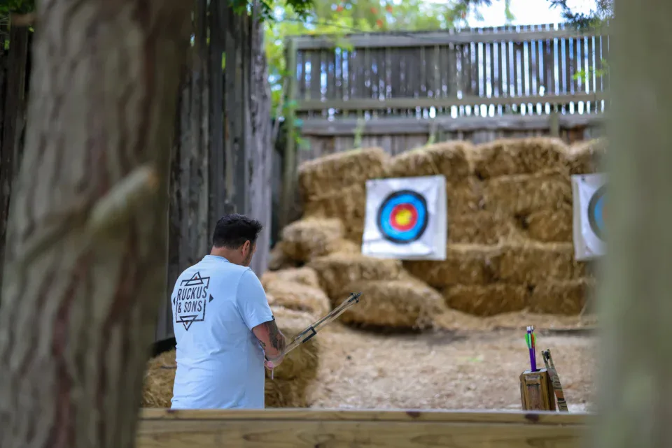 Team Building Archer lining up a shot at targets on hay bales, Old Mac Daddy, Elgin Valley
