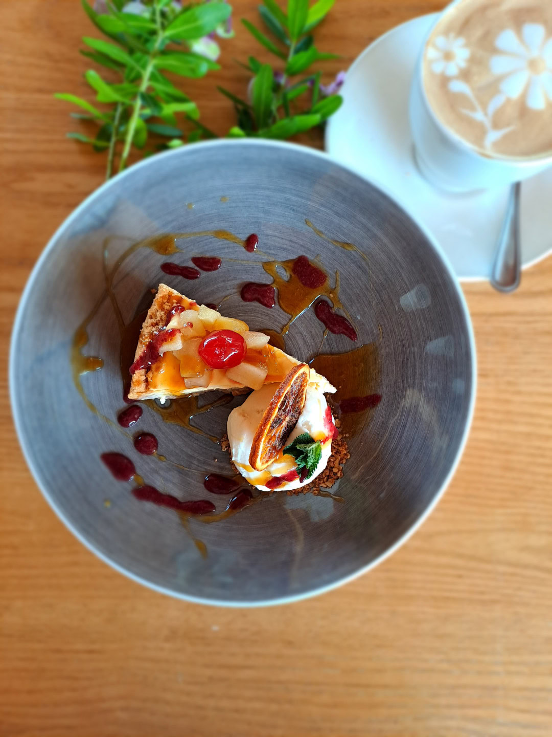 A plated dessert with berry sauce, beside a cappuccino, Old Mac Daddy, Elgin Valley