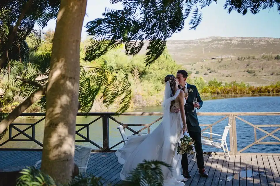 Weddings & Events Bride and groom on the lakeside deck in the shade of a tree, hills across the water, Old Mac Daddy, Elgin Valley