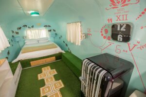 Dig'It: Airstream bedroom with a clock-face mural and a hopscotch grid on an artificial-grass floor, Old Mac Daddy, Elgin Valley