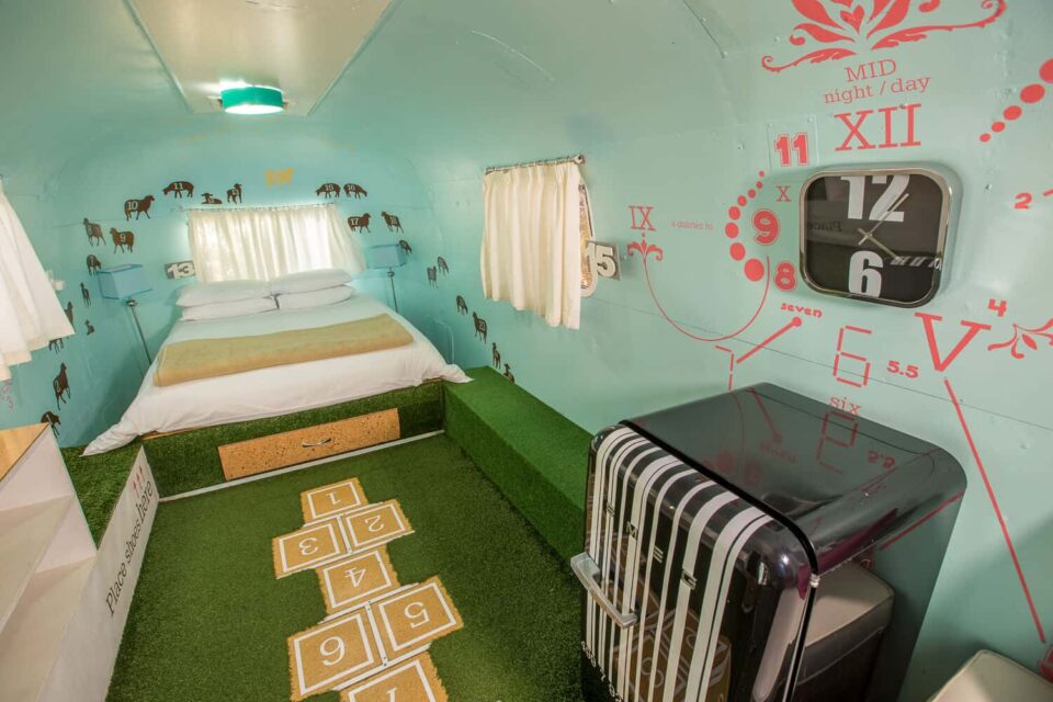 Dig'It: Airstream bedroom with a clock-face mural and a hopscotch grid on an artificial-grass floor, Old Mac Daddy, Elgin Valley