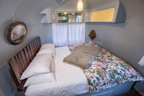 For Better or Boerewors: bed with a floral duvet and a dark wooden headboard, Old Mac Daddy, Elgin Valley