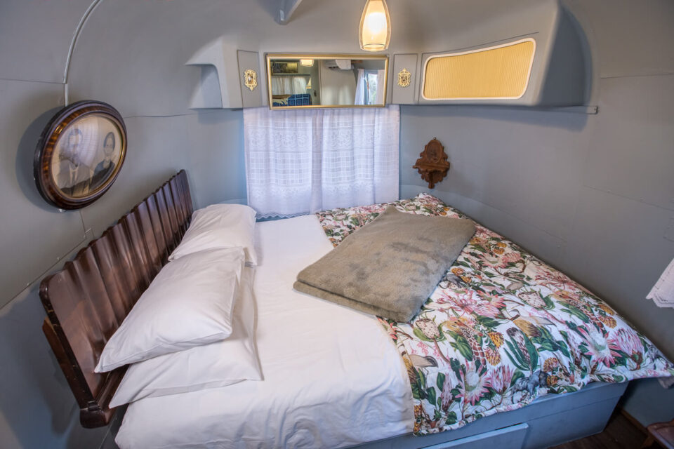 For Better or Boerewors: bed with a floral duvet and a dark wooden headboard, Old Mac Daddy, Elgin Valley