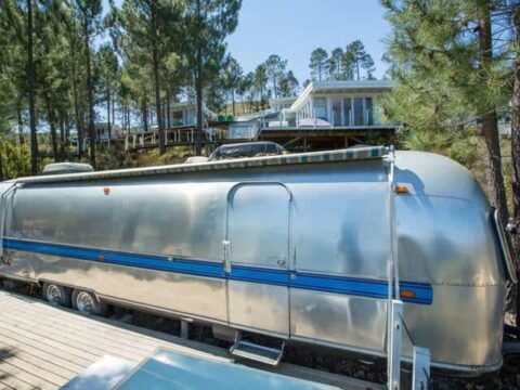 Life Before Colour: the silver Airstream with a blue stripe, glass-decked units in the pines behind, Old Mac Daddy, Elgin Valley