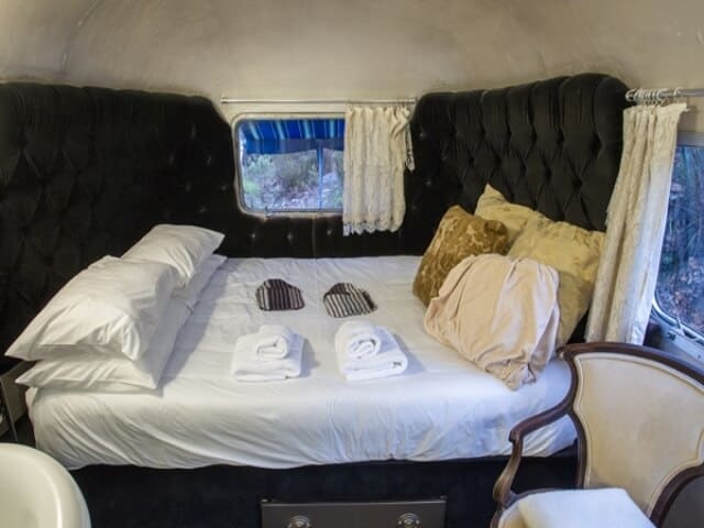 Life Before Colour: Airstream bed with a black buttoned headboard and gold cushions, Old Mac Daddy, Elgin Valley