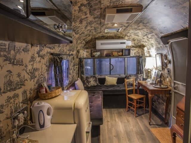 Life Before Colour: Airstream interior in toile wallpaper, lounge and writing desk at the far end, Old Mac Daddy, Elgin Valley