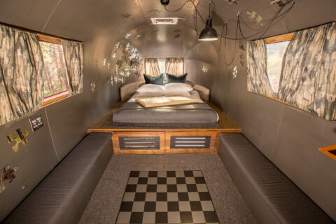 Metalmorphosis: raised Airstream bed, grey banquettes and a chequered floor panel, puzzle-piece decor, Old Mac Daddy, Elgin Valley
