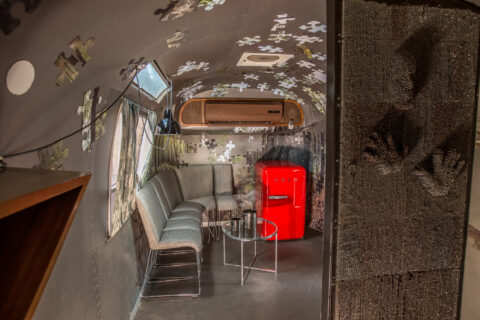 Metalmorphosis: grey lounge seating and a red SMEG fridge, puzzle pieces on the walls, Old Mac Daddy, Elgin Valley