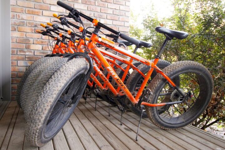 A row of orange fat-tyre bikes parked on a wooden deck, Old Mac Daddy, Elgin Valley