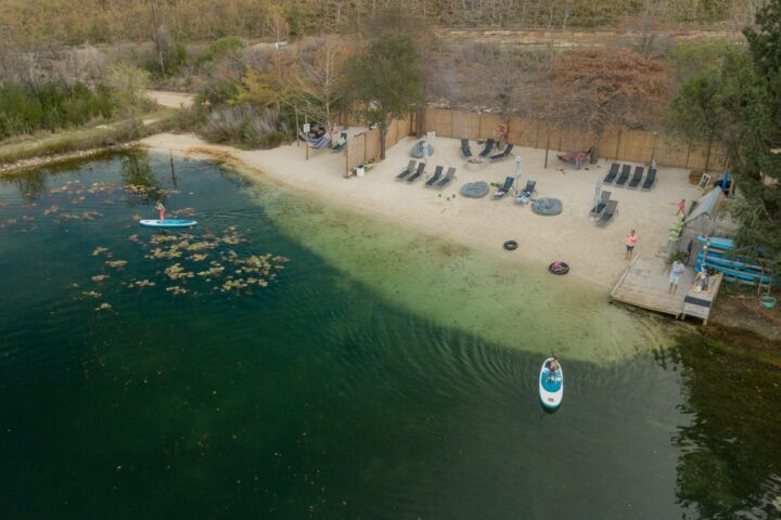 Aerial view of the lakeside beach with loungers and paddle boarders on the water, Old Mac Daddy, Elgin Valley