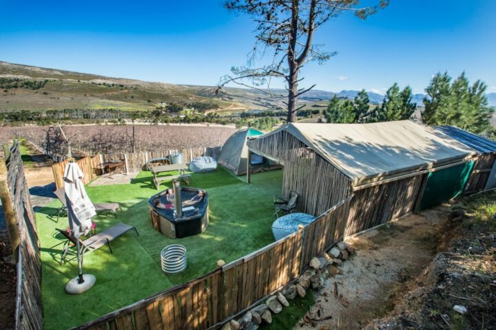 Campsite with a wood-fired hot tub, tents and a reed shelter, seen from above, Old Mac Daddy, Elgin Valley