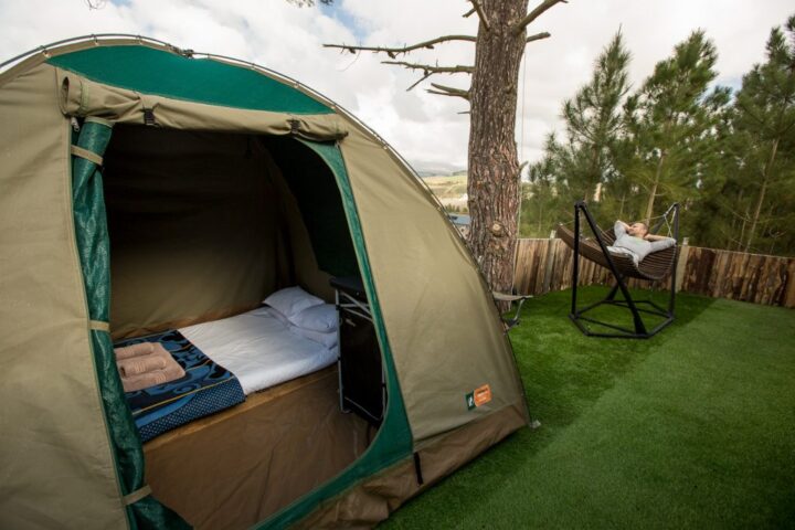 Inside a dome tent with a made-up bed, and a guest in a hammock outside, Old Mac Daddy, Elgin Valley