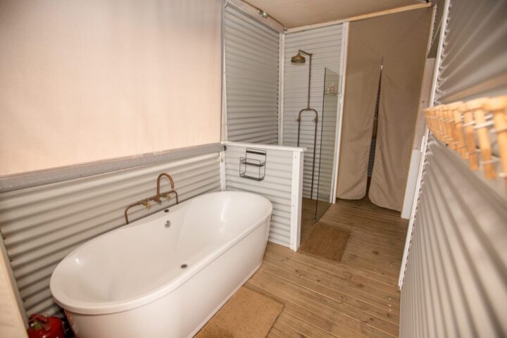 Freestanding bath and a copper shower in a bathroom with corrugated-iron walls, Old Mac Daddy, Elgin Valley