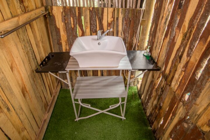 Washbasin on a camp stand inside a timber-walled enclosure, Old Mac Daddy, Elgin Valley