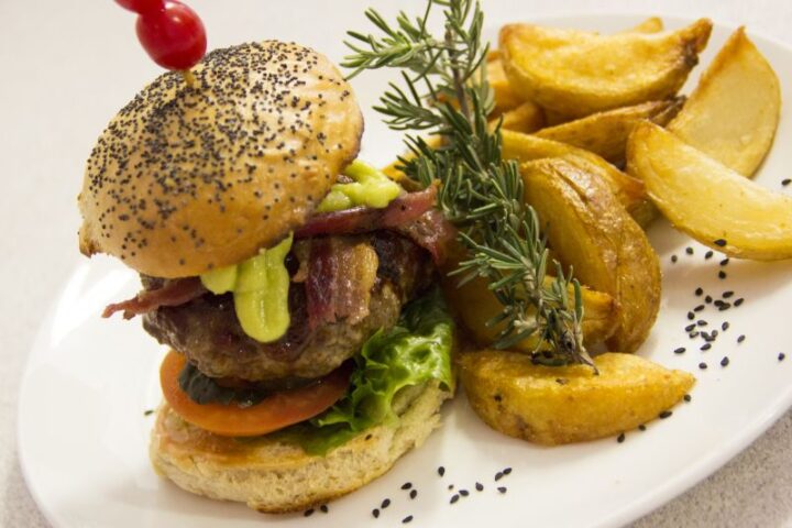 A burger with bacon and potato wedges, garnished with rosemary, Old Mac Daddy, Elgin Valley